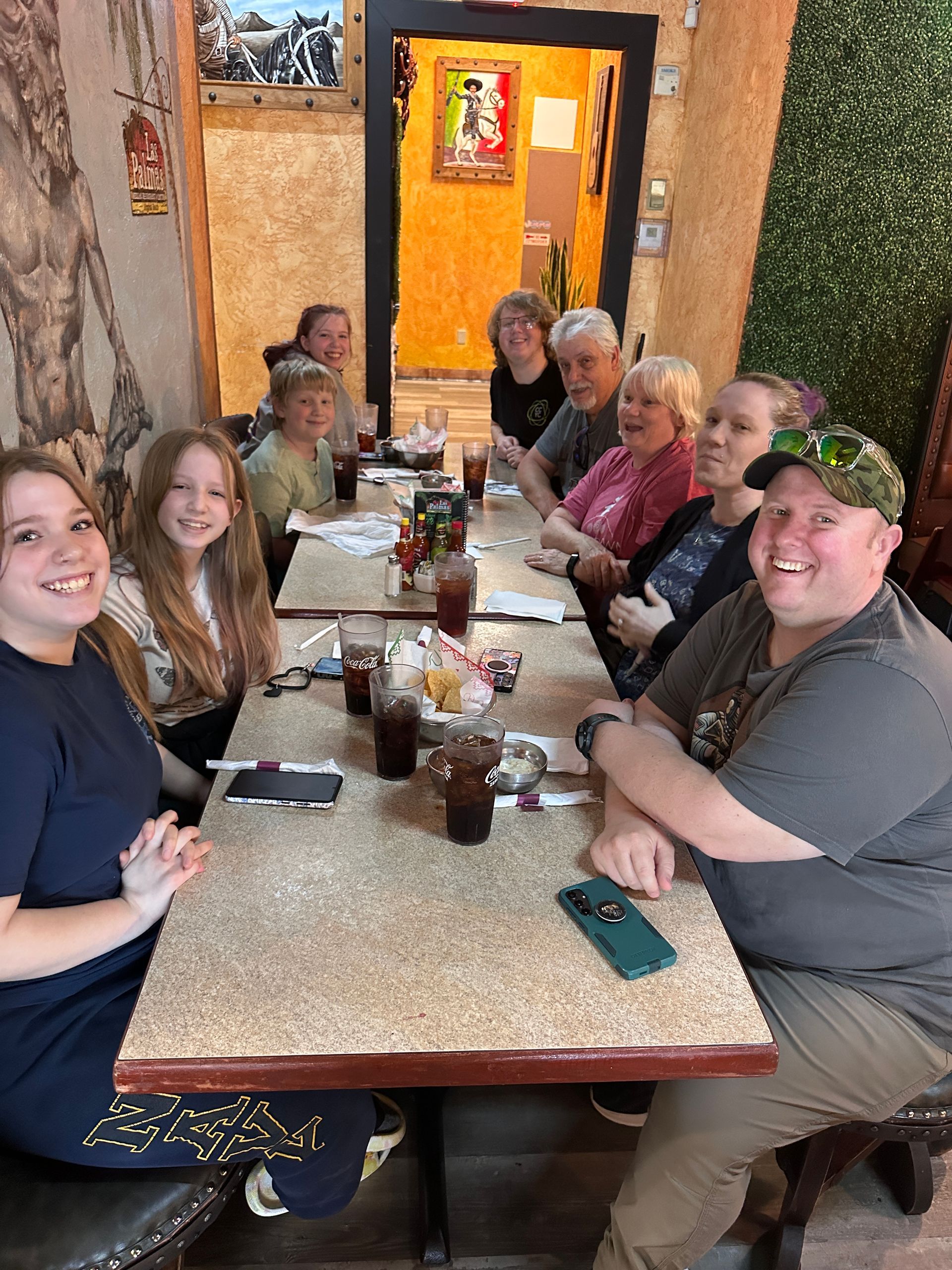 People seated at a table in a restaurant. They are smiling and looking at the camera.