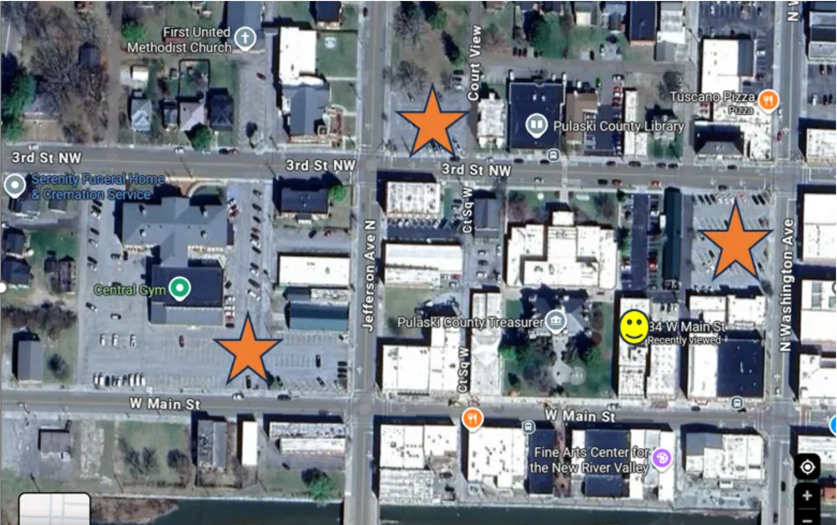 Overhead view of a downtown area with buildings, streets, and orange star icons marking locations.
