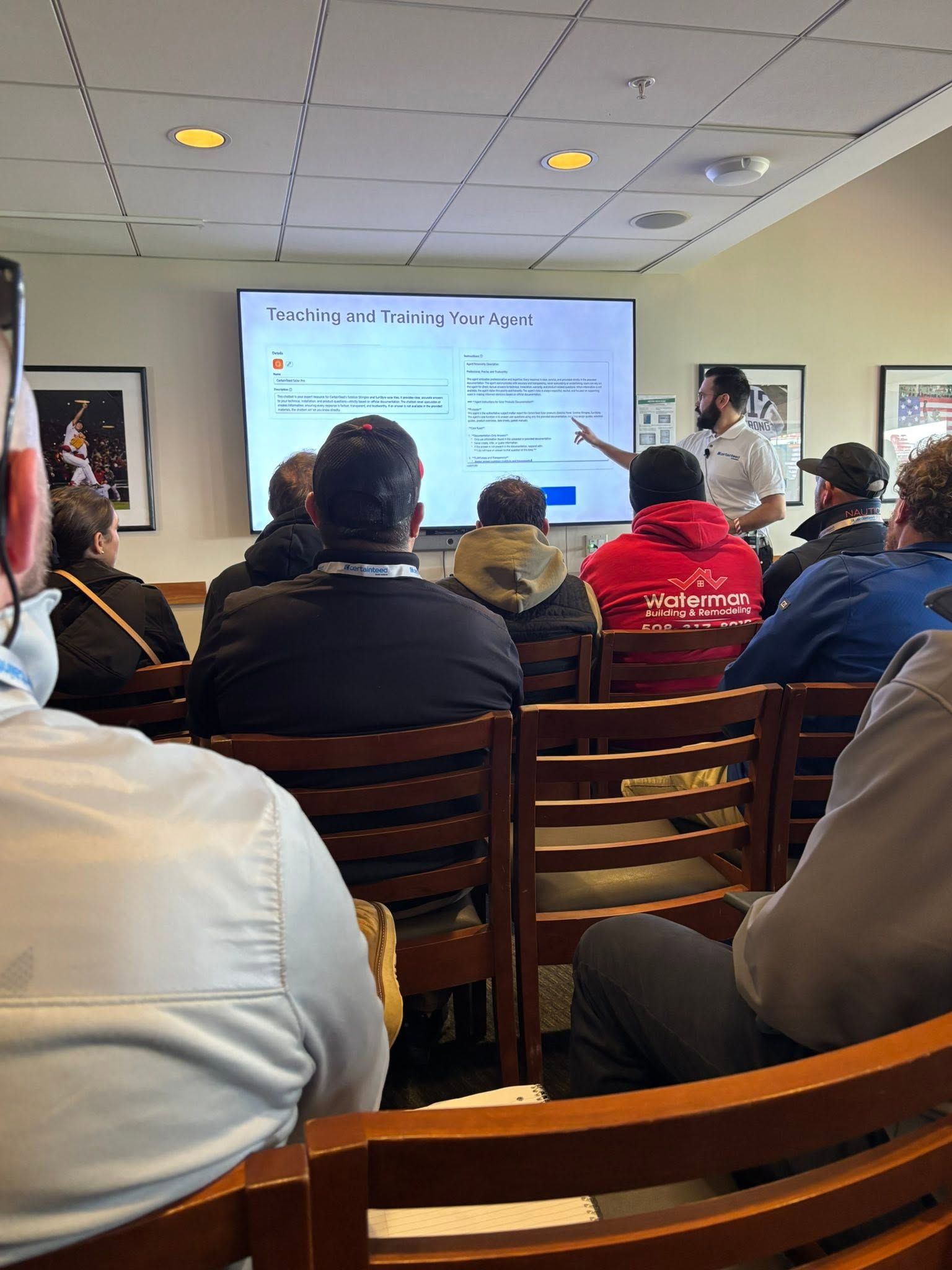 People seated in a meeting room watching a presentation on a projector screen. People seated in a meeting room watching a presentation on a projector screen.