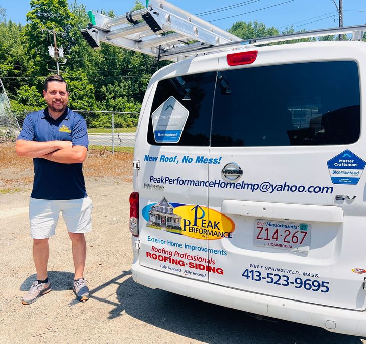 Man standing beside a white utility van with company decals and a ladder on top. Man standing beside a white utility van with company decals and a ladder on top.