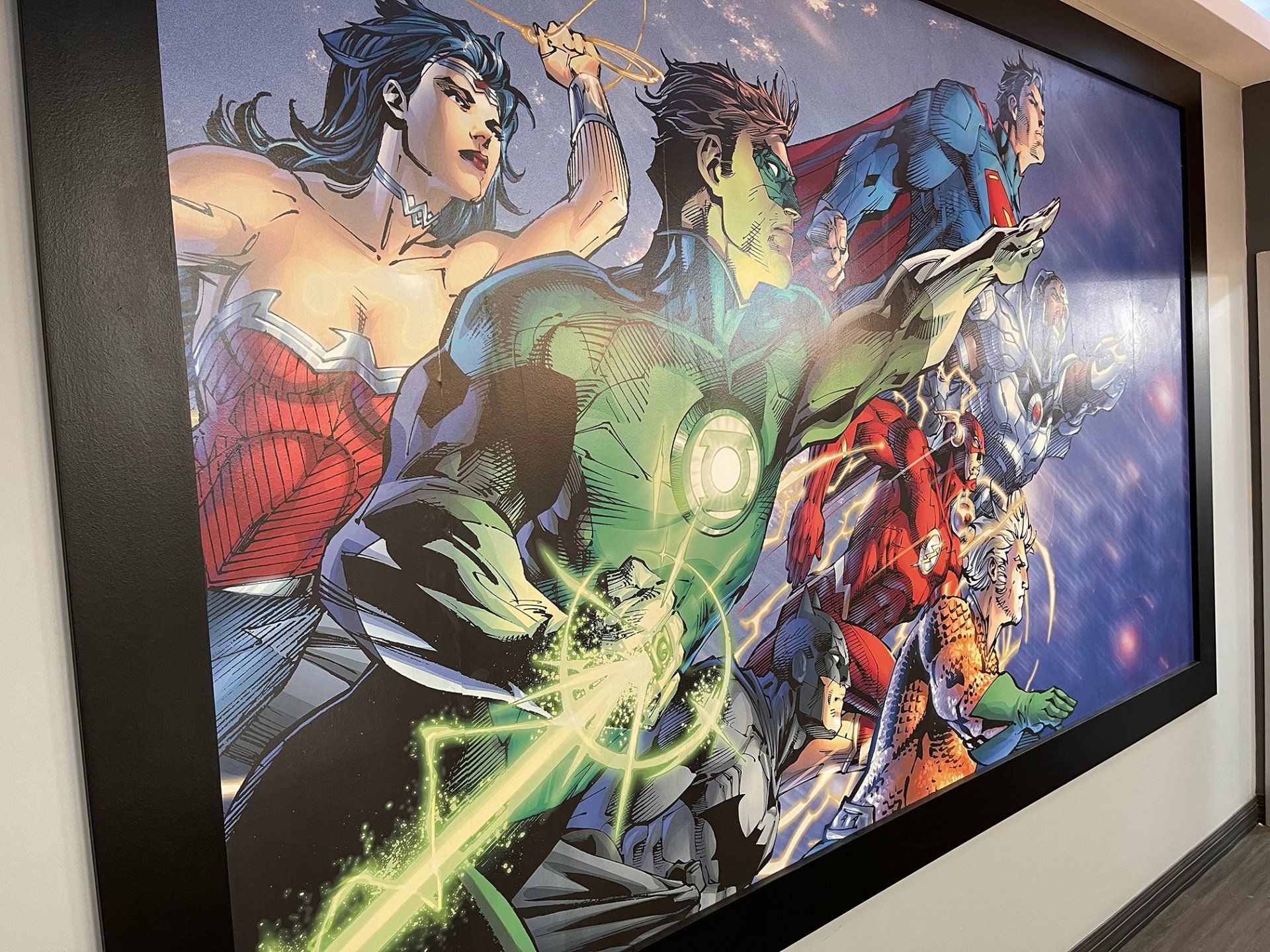 Comic-style superhero mural with Green Lantern and other DC heroes on a wall