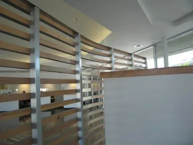 Modern office interior with wood slat partition, white walls, and large windows