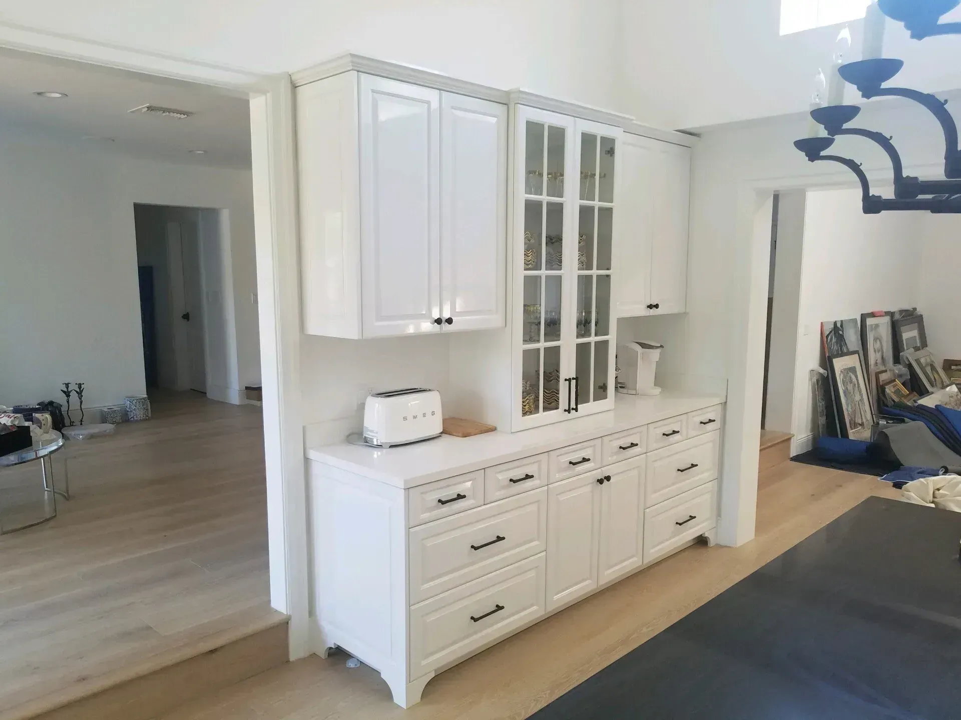 White built-in cabinets and drawers in a bright room with a light wood floor and black yoga mat.