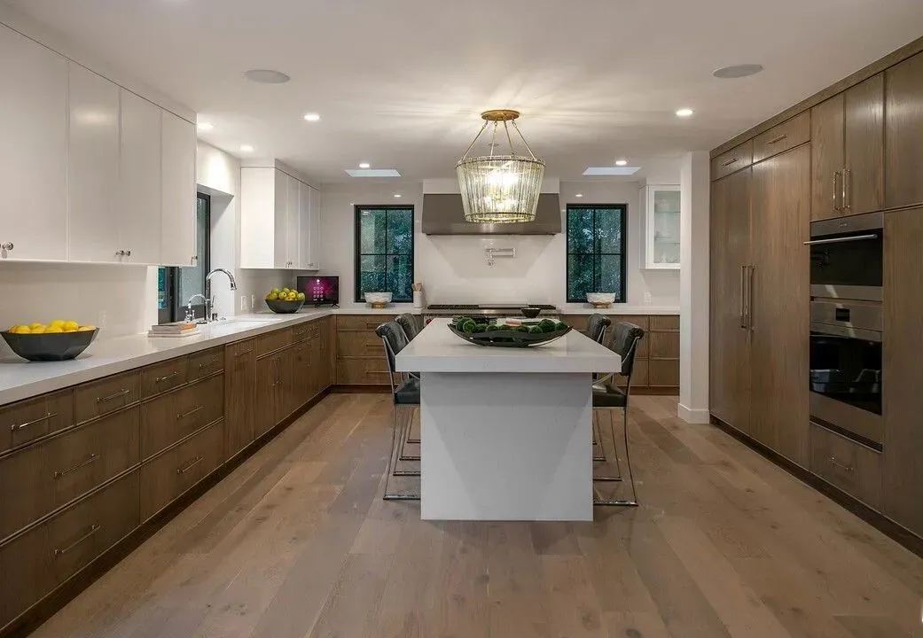 Bright modern kitchen with wood cabinets, white island, and pendant light