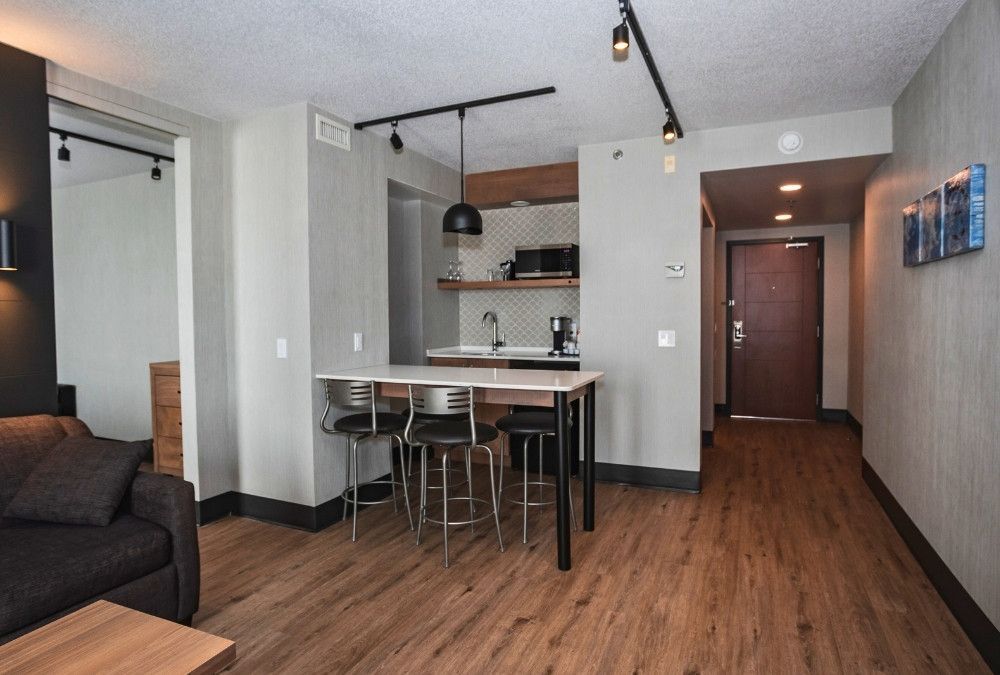 Une suite d'hôtel avec un salon avec un canapé, une table et des chaises
