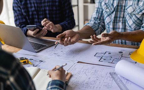 Un groupe de personnes est assise autour d'une table et regarde un plan.