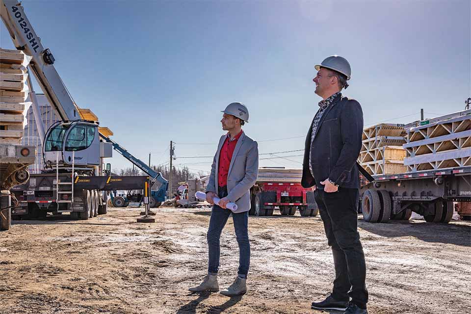 deux hommes se tiennent côte à côte sur un chantier de construction.