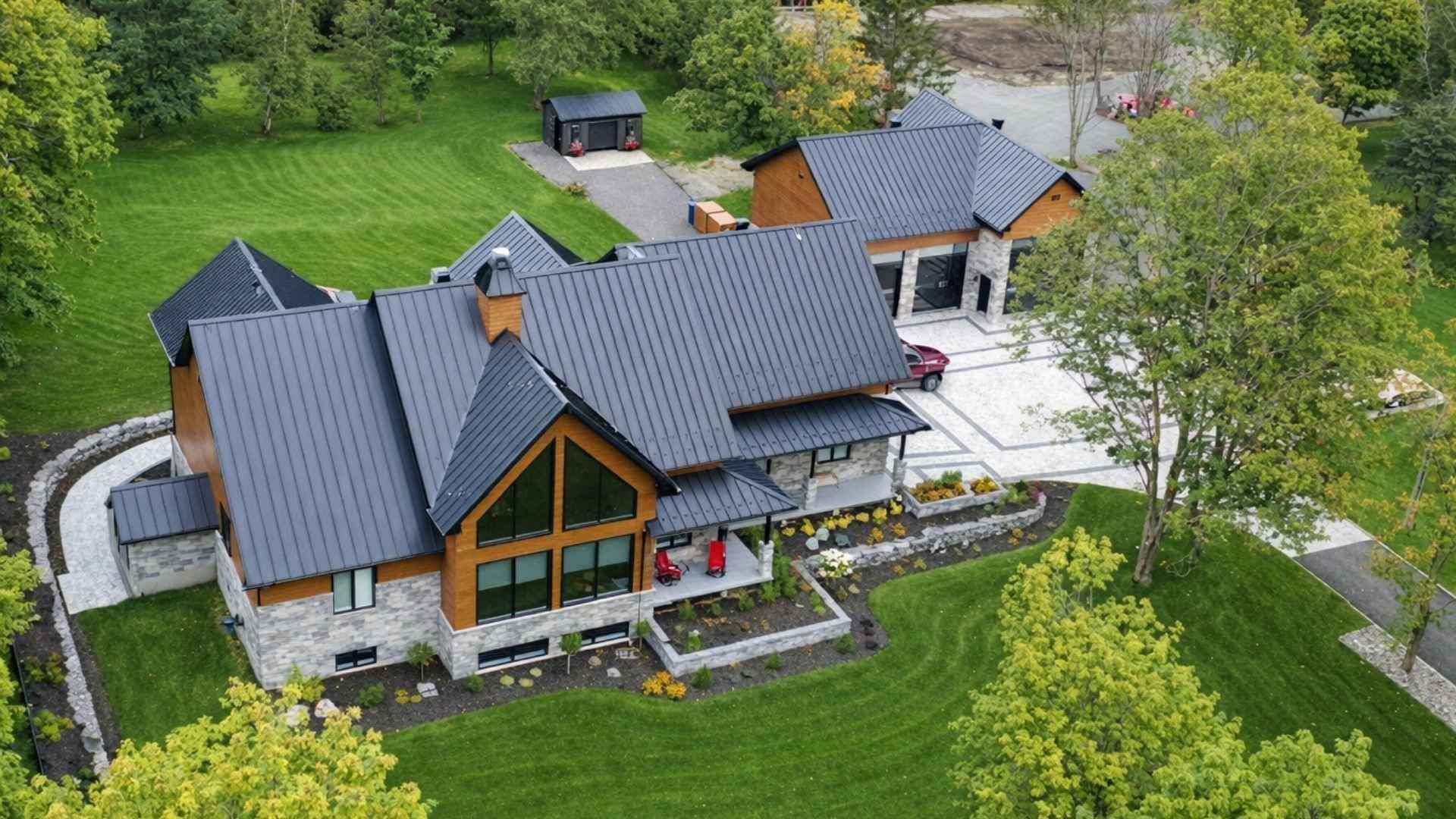 Une vue aérienne d'une grande maison entourée d'arbres et d'herbe.