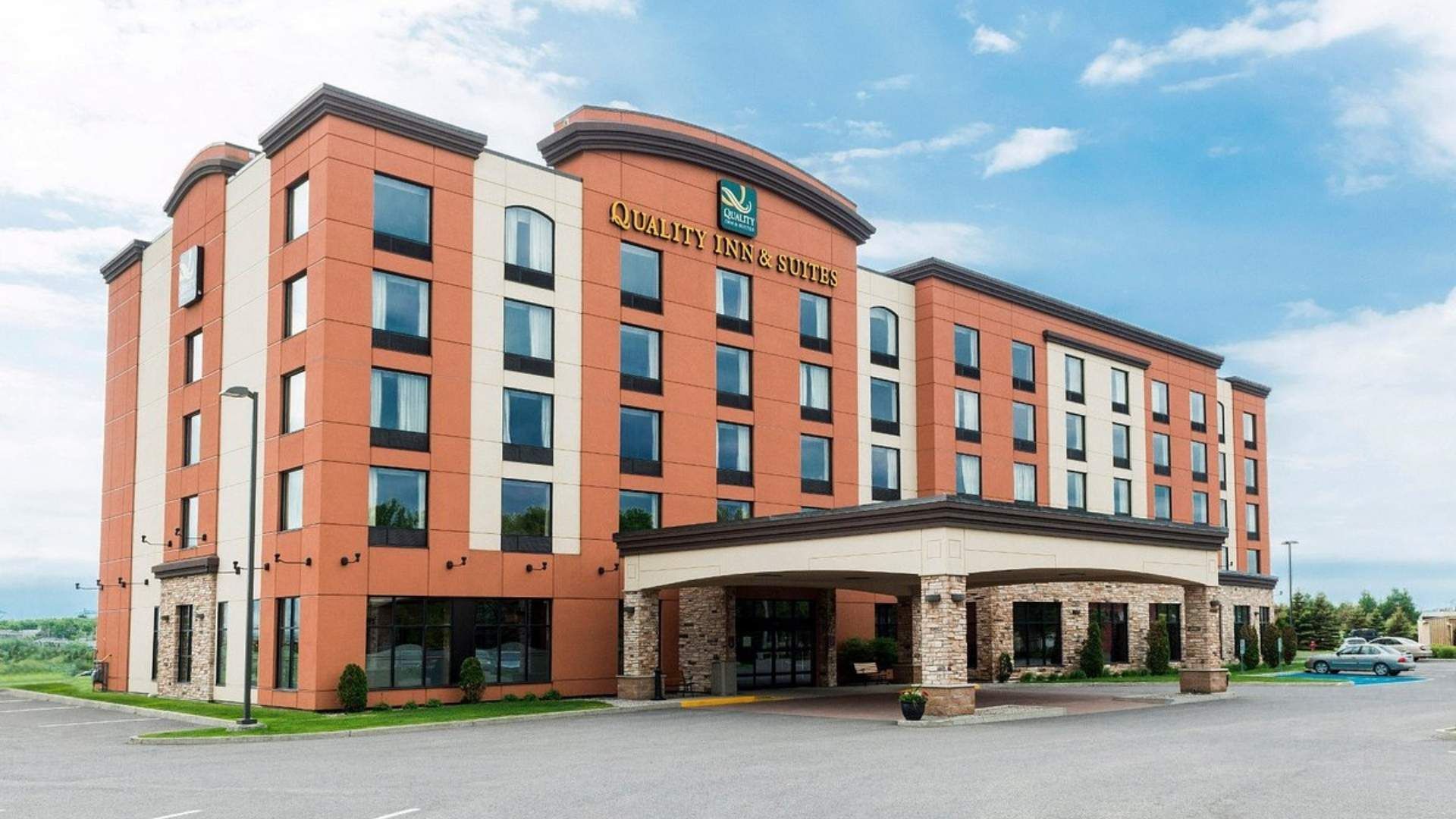 Extérieur du Quality Inn and Suites, un grand bâtiment d'hôtel de couleur orange .