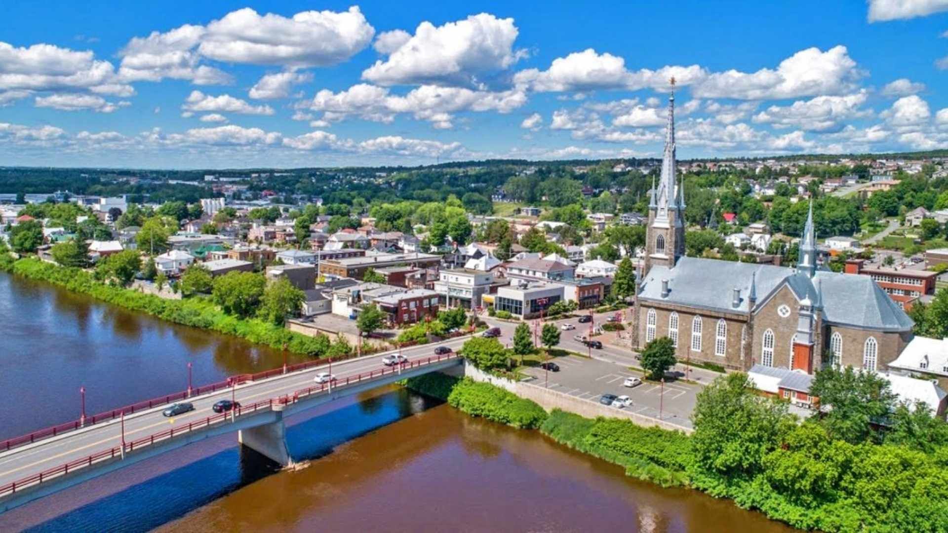 Vue aérienne de Sainte-Marie de Beauce avec un pont, un clocher d'église.