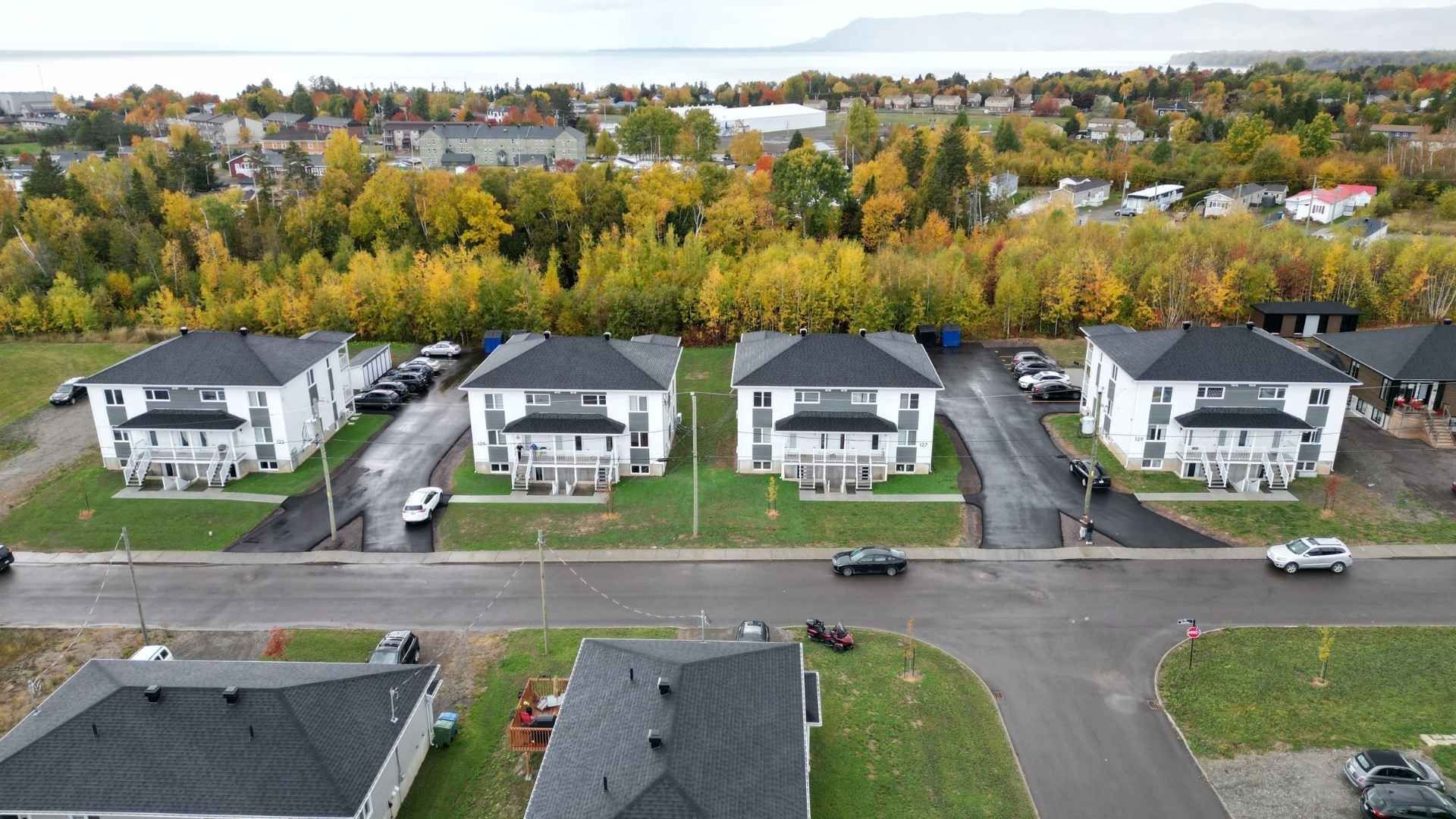 un grand immeuble avec des voitures garées devant.