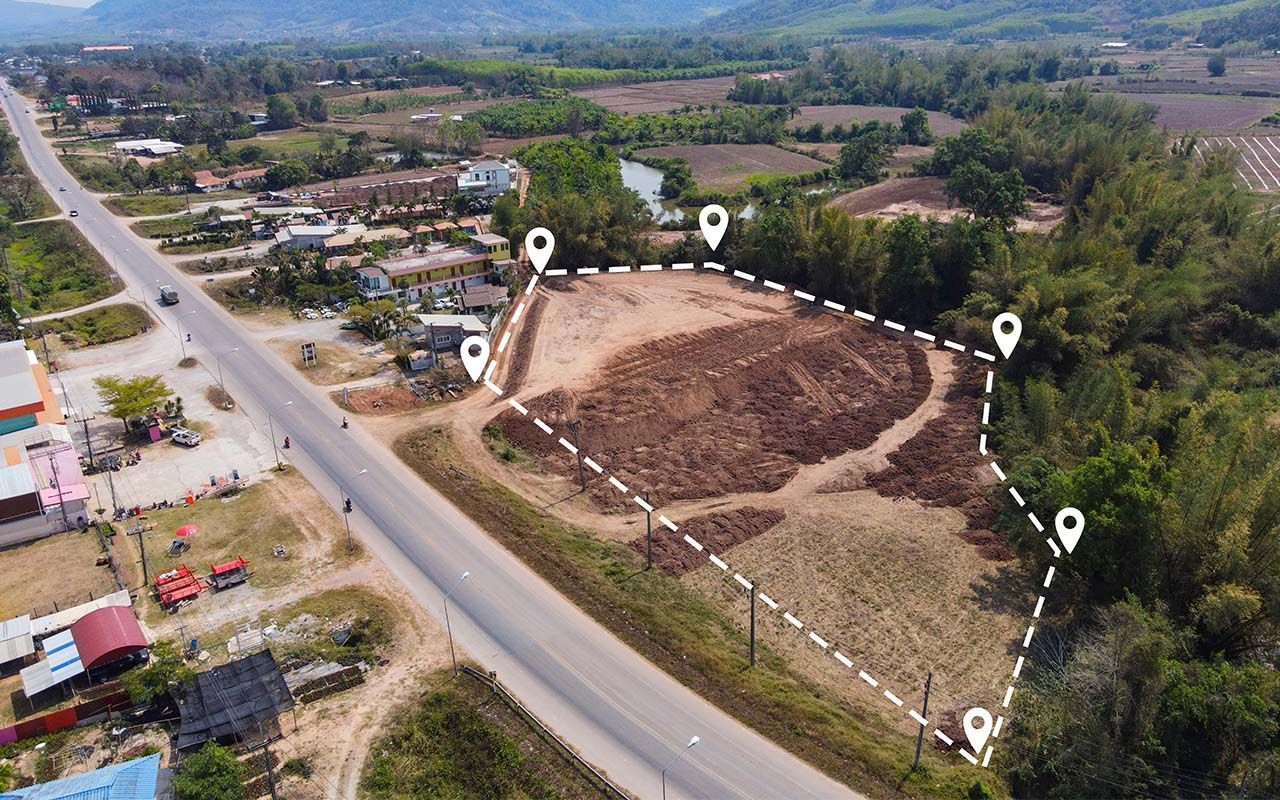 An aerial view of a dirt field next to a road.