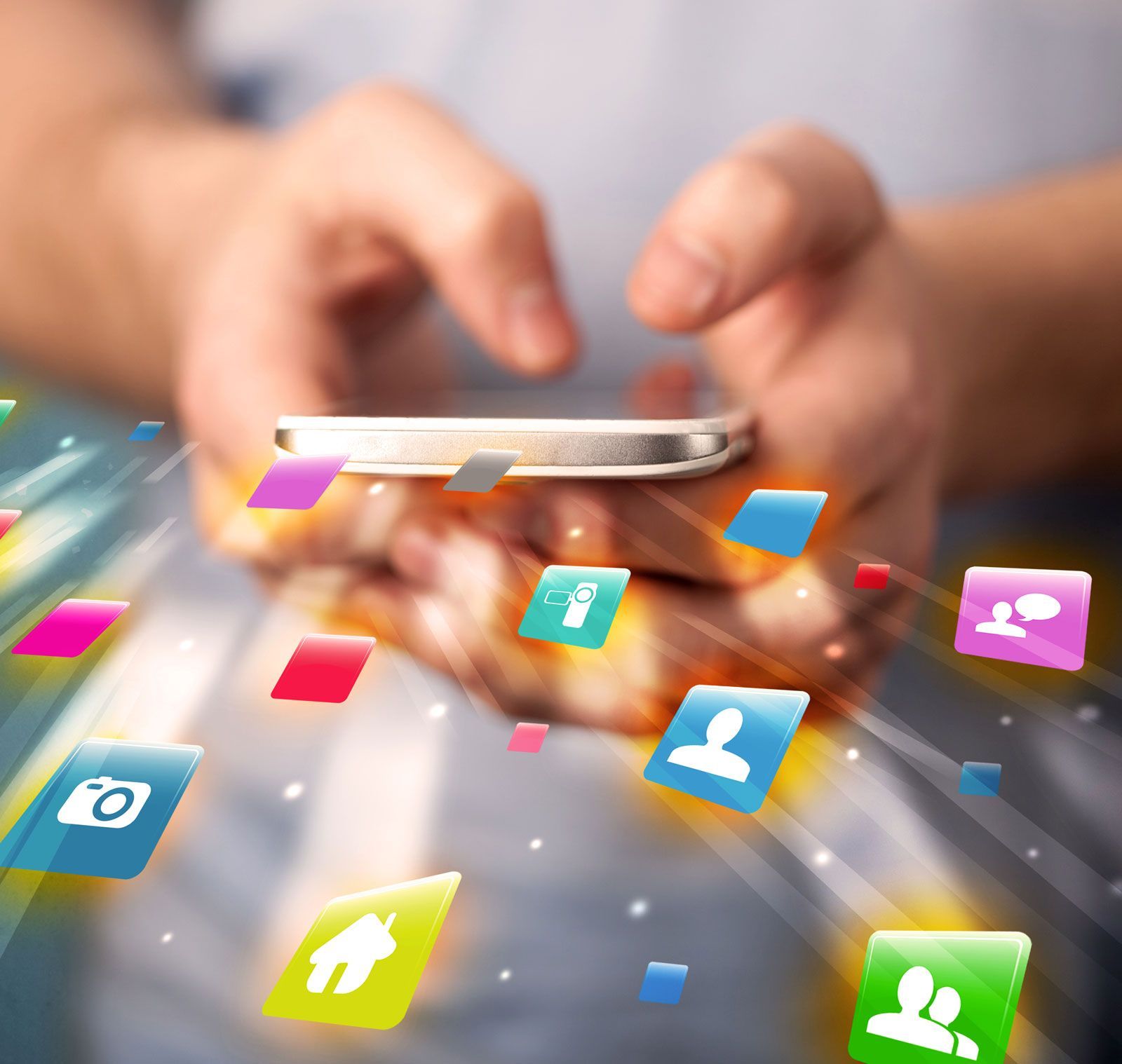 A person is holding a cell phone with icons coming out of it