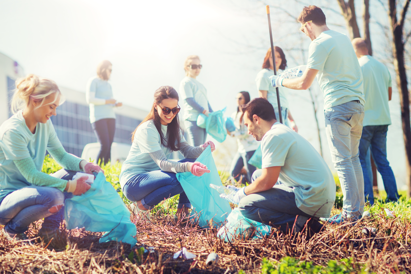 A group of people are picking up trash in a park.