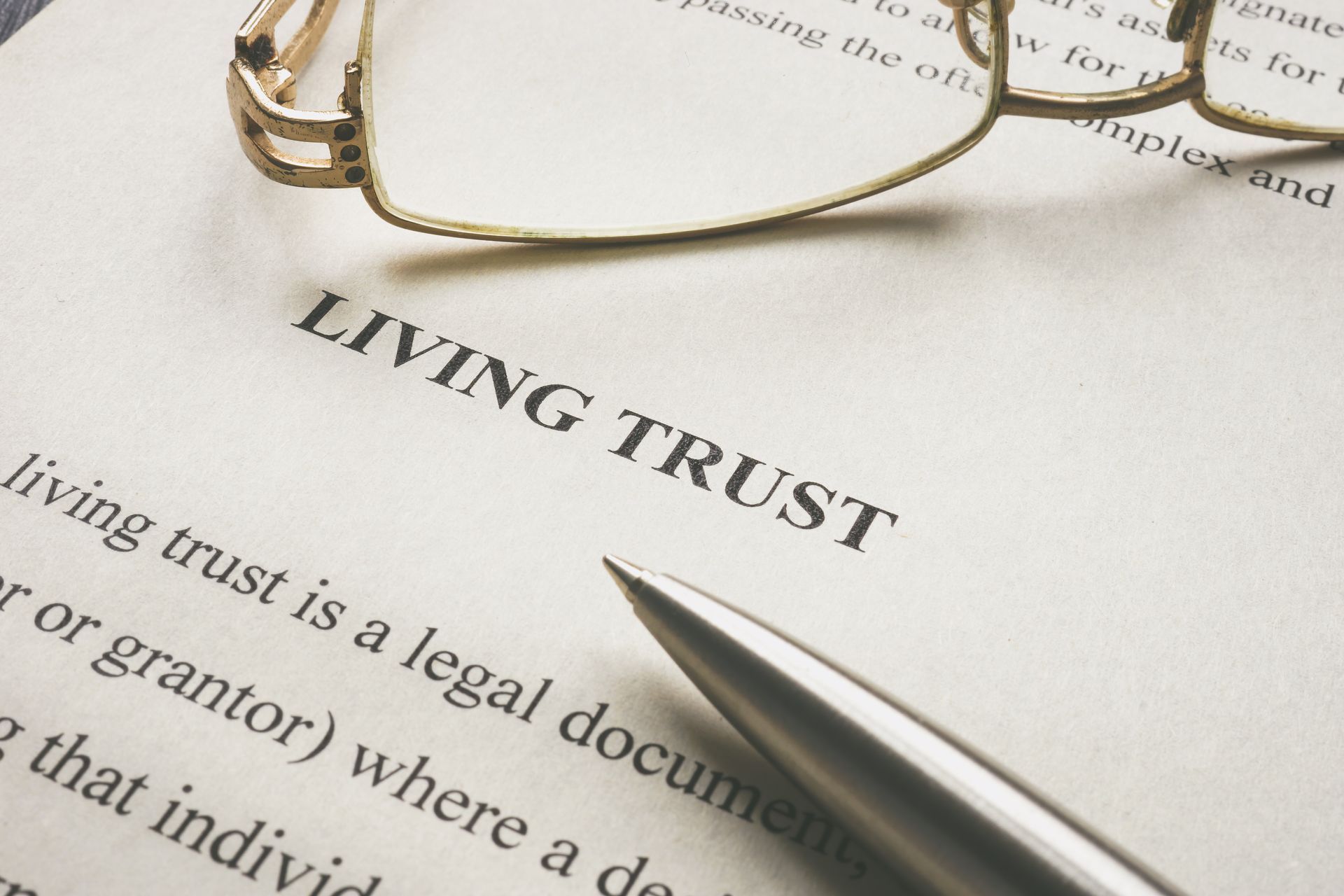 Document with information about a living trust and glasses on it.