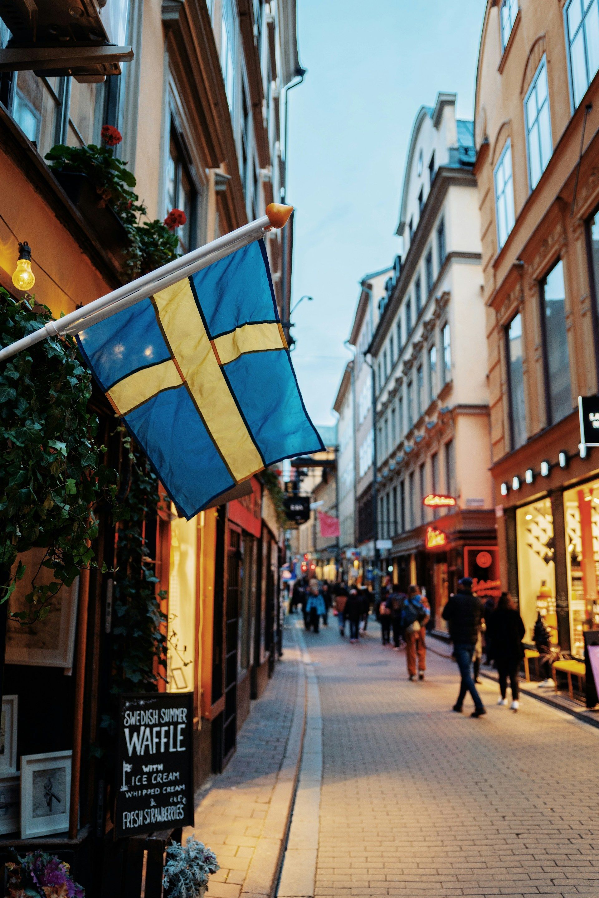 En smal gate med et svensk flagg hengende fra en stang