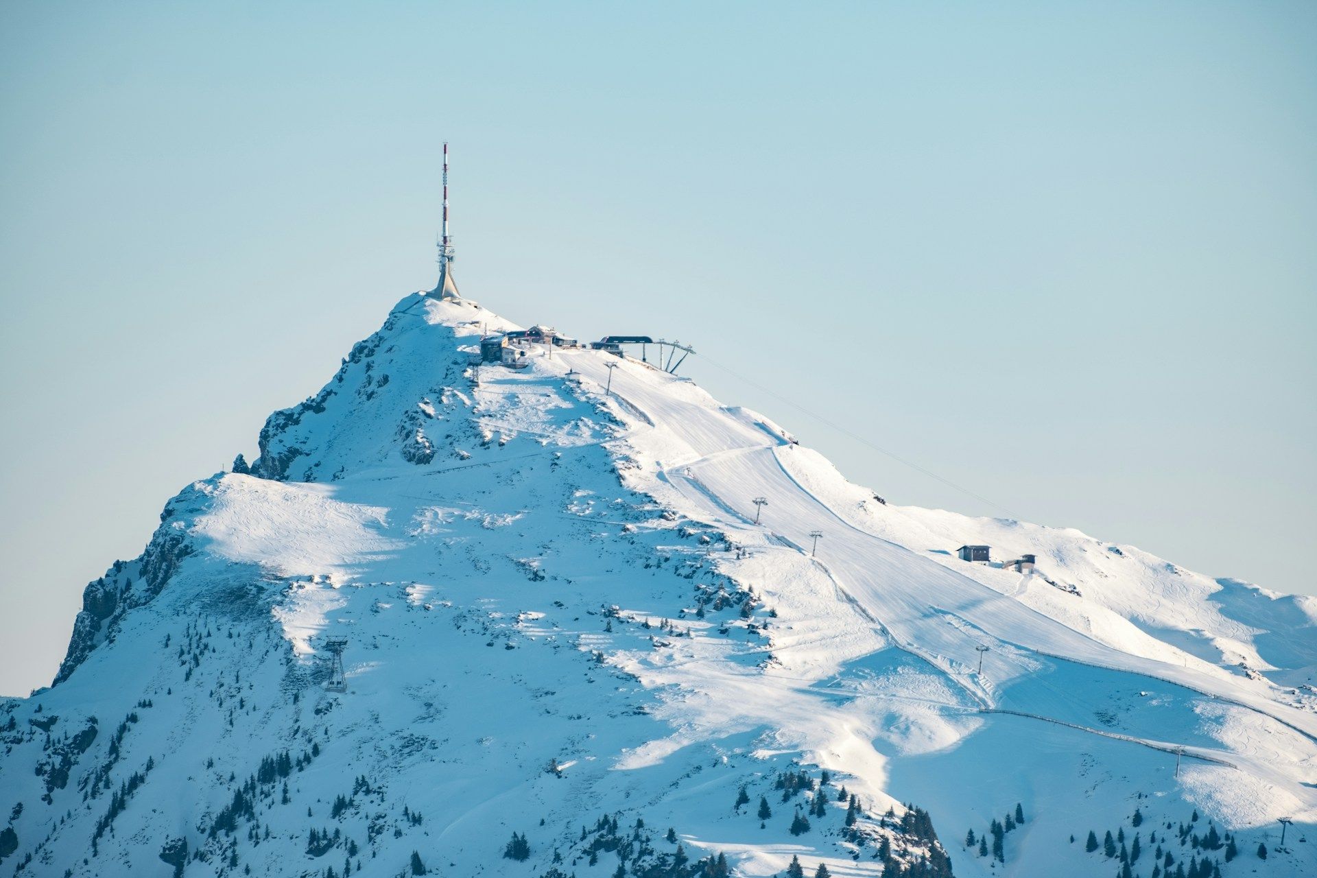 Et snødekt fjell med et tårn på toppen