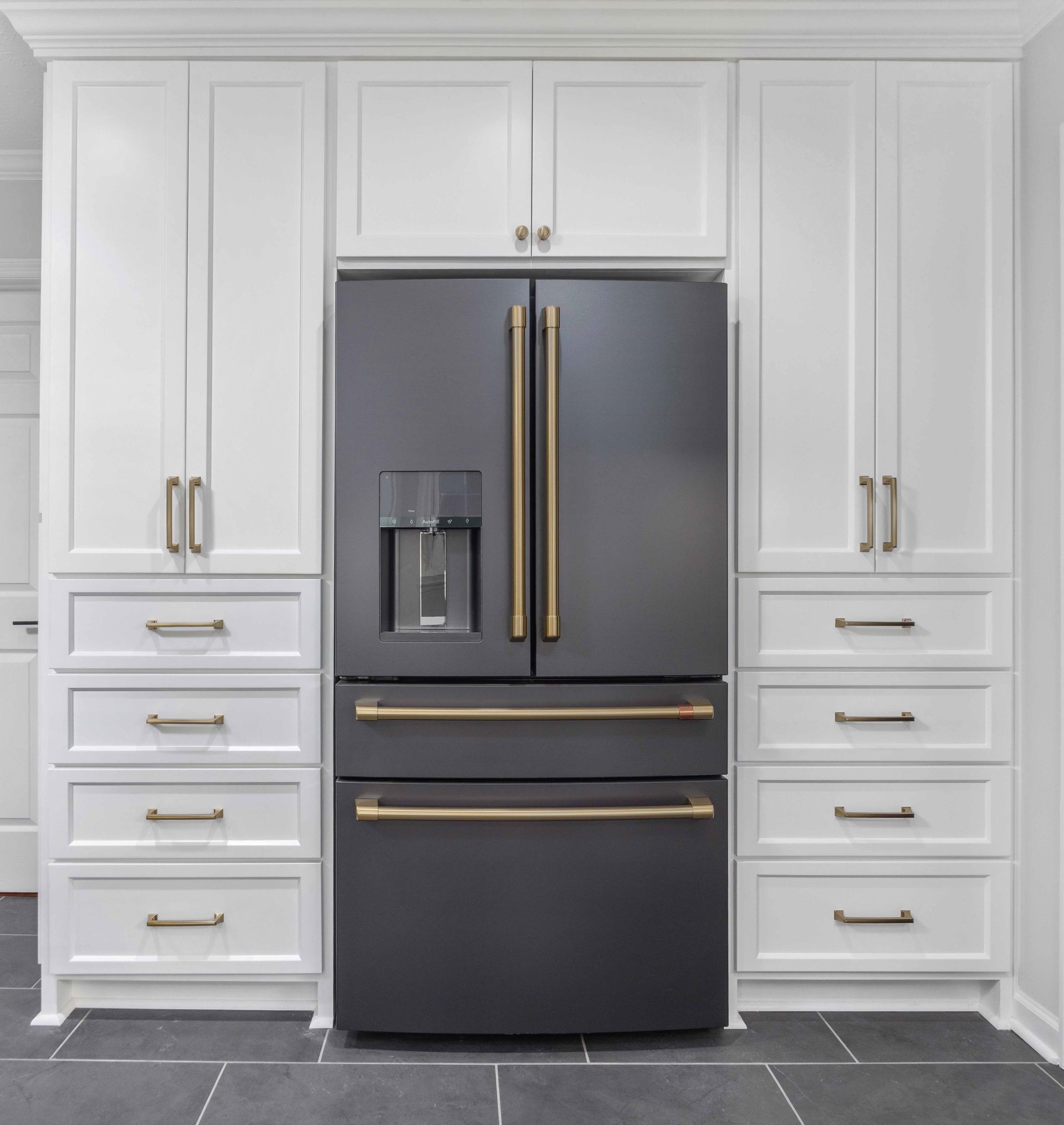 White kitchen with built-in cabinets and a black French-door refrigerator with gold handles