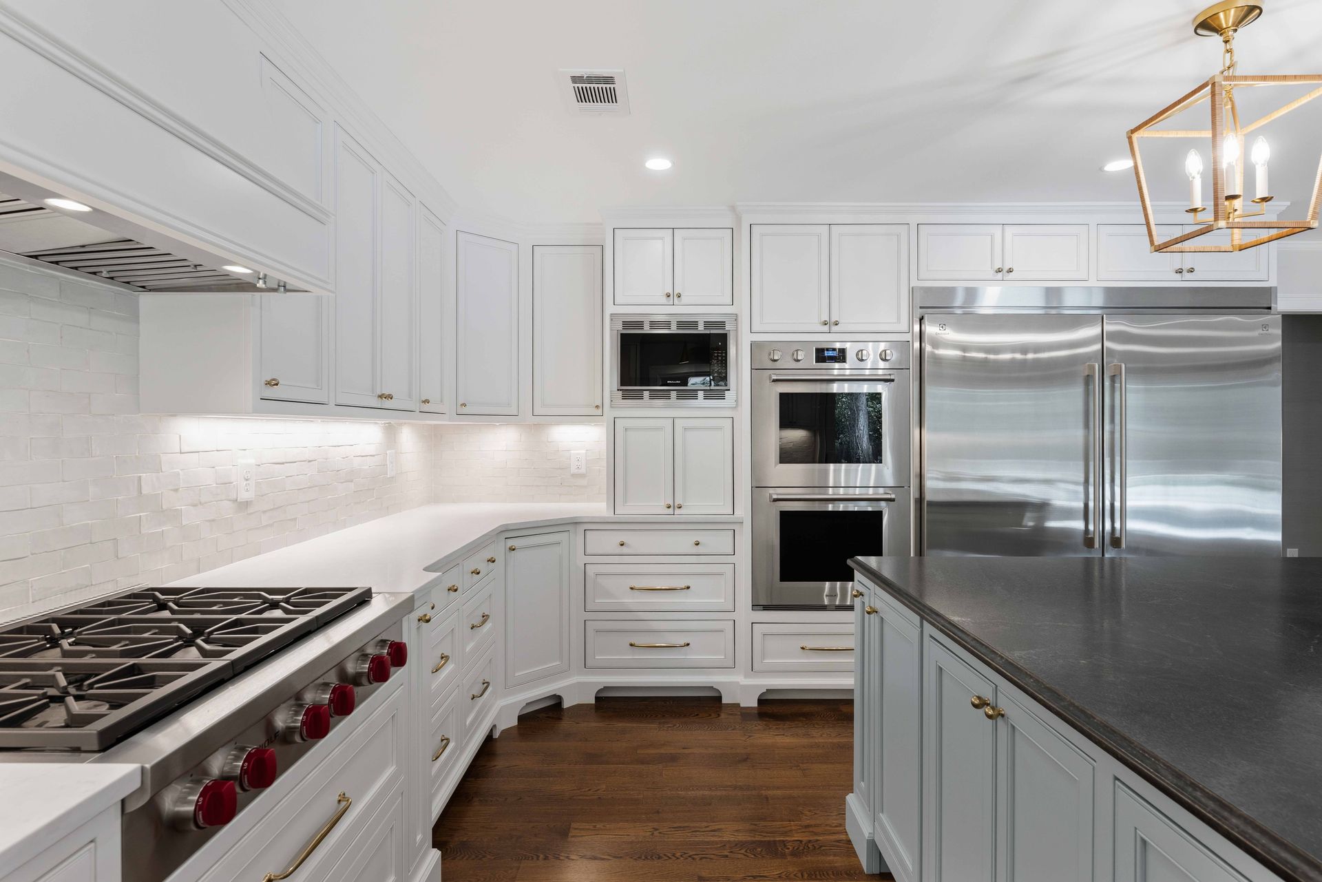 Bright modern white kitchen with stainless steel appliances and dark countertops