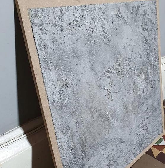 Board displaying grey, textured venetian plastering