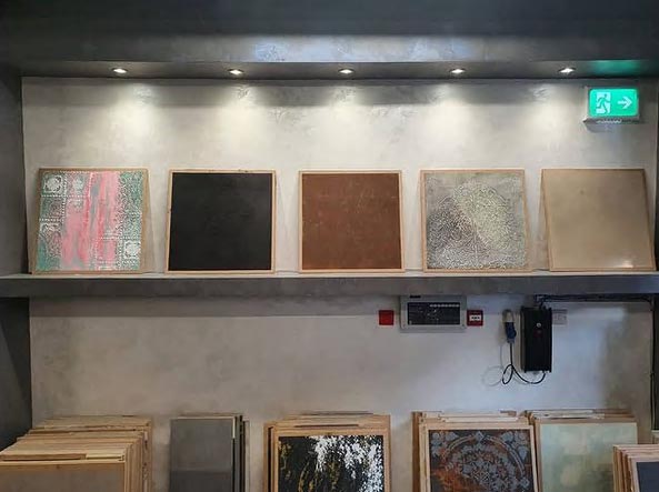 Two shelves of boards displaying different plastering finishes