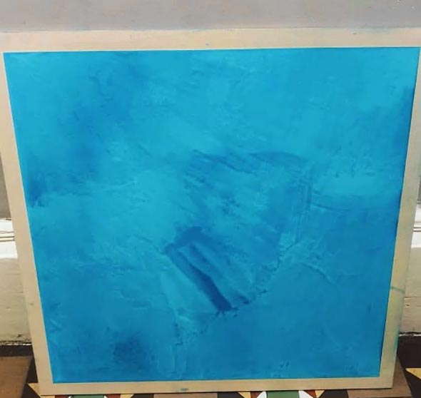 Square board displaying bright blue plaster finish