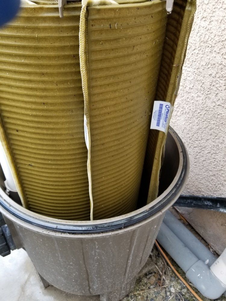 Yellow rolled material in a metal bin outdoors, with a small label attached.