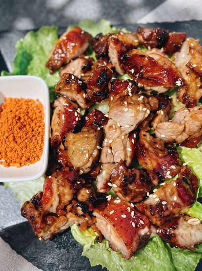 Grilled meat salad with lettuce and orange seasoning in a small dish