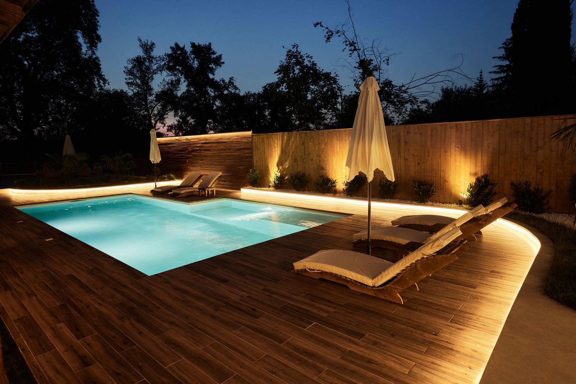 A large swimming pool is lit up at night