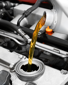 Pouring amber motor oil into a car engine fill port | Walt Eger's Service Center