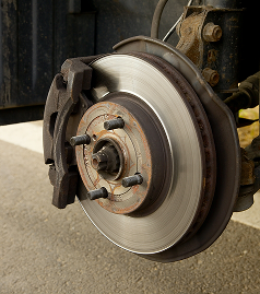 Close-up of a car’s brake disc and caliper with the wheel removed | Walt Eger's Service Center