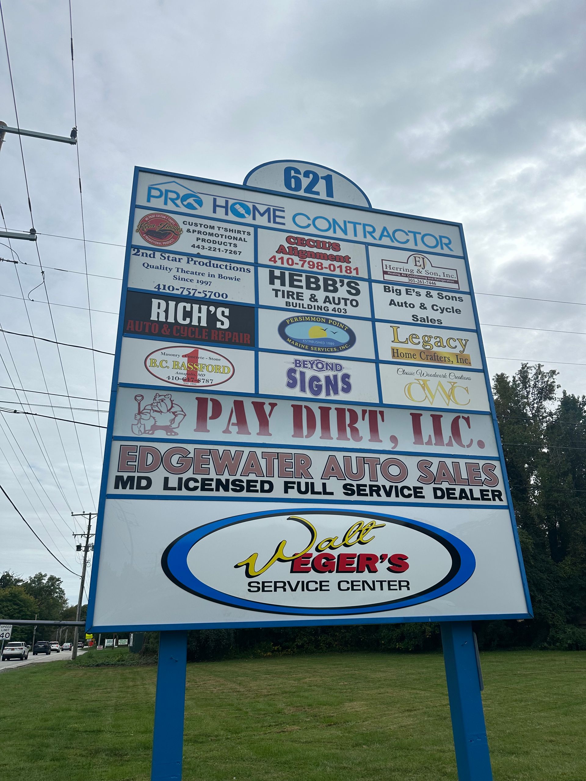 Walt Eger’s Service Center storefront with red roof, white building, and flower bed sign by the road with Walt Eger's team | Walt Eger's Service Center