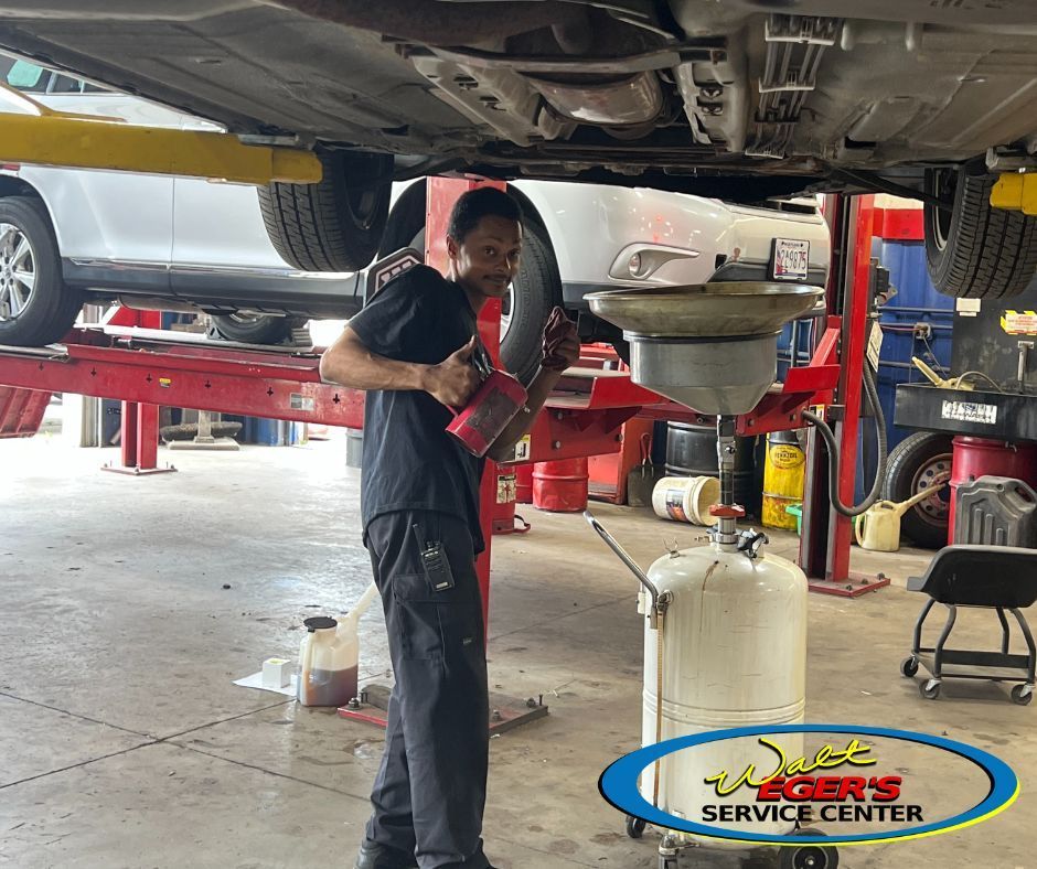 Mechanic inspecting a car on a lift | Walt Eger's Service Center