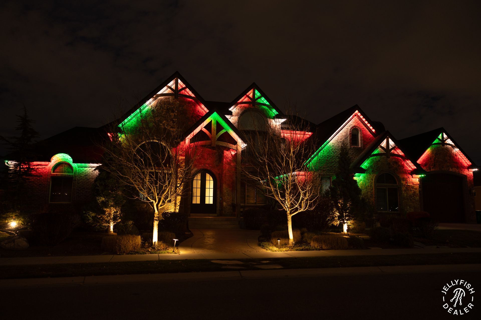 A house is lit up with red , green and white christmas lights.