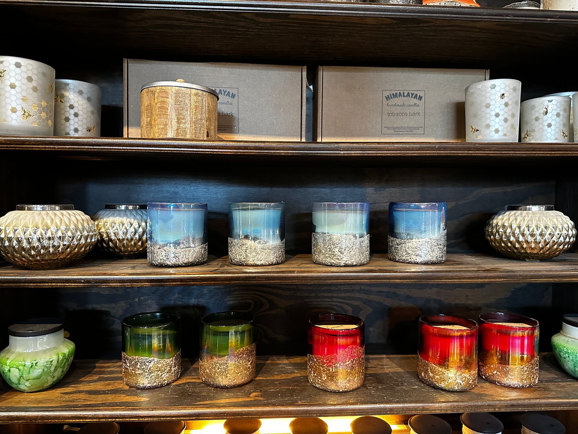 A shelf with candles and vases on it