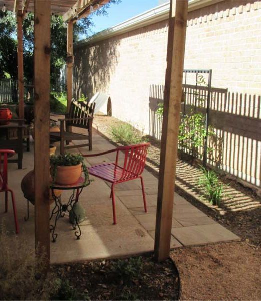 A patio with chairs and a table under a canopy