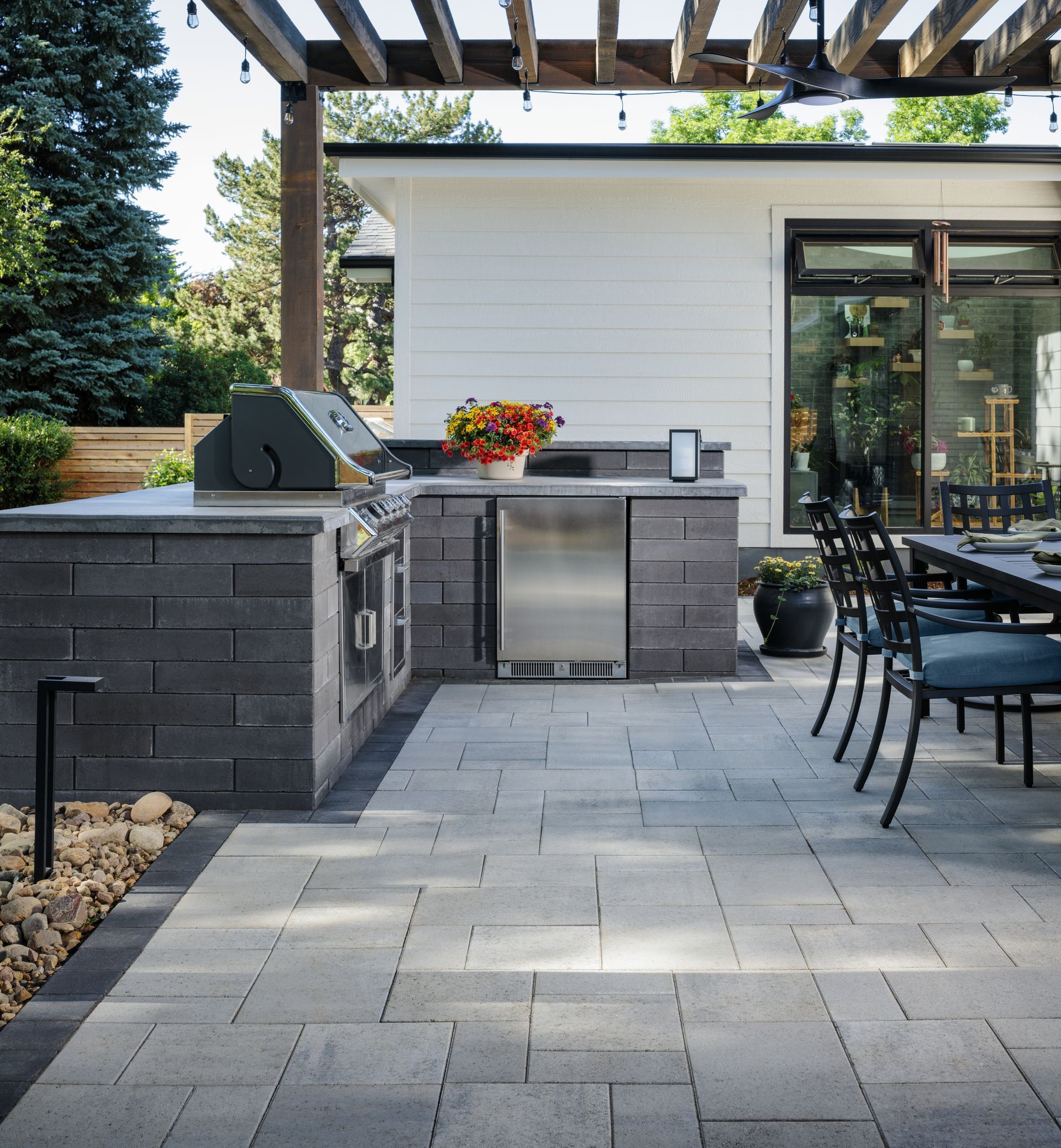 A patio with a table and chairs and a grill