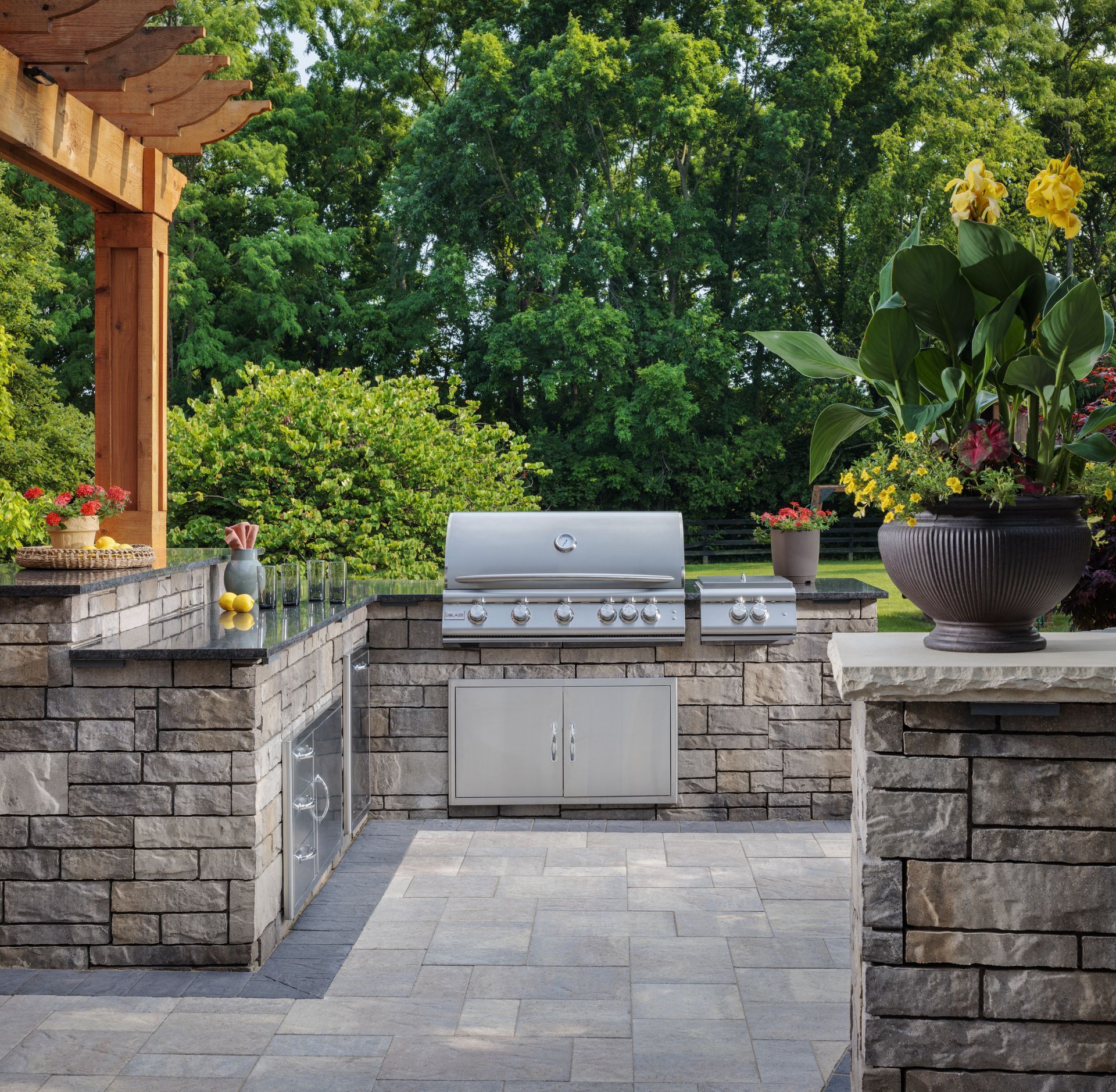 An outdoor kitchen with a stainless steel grill
