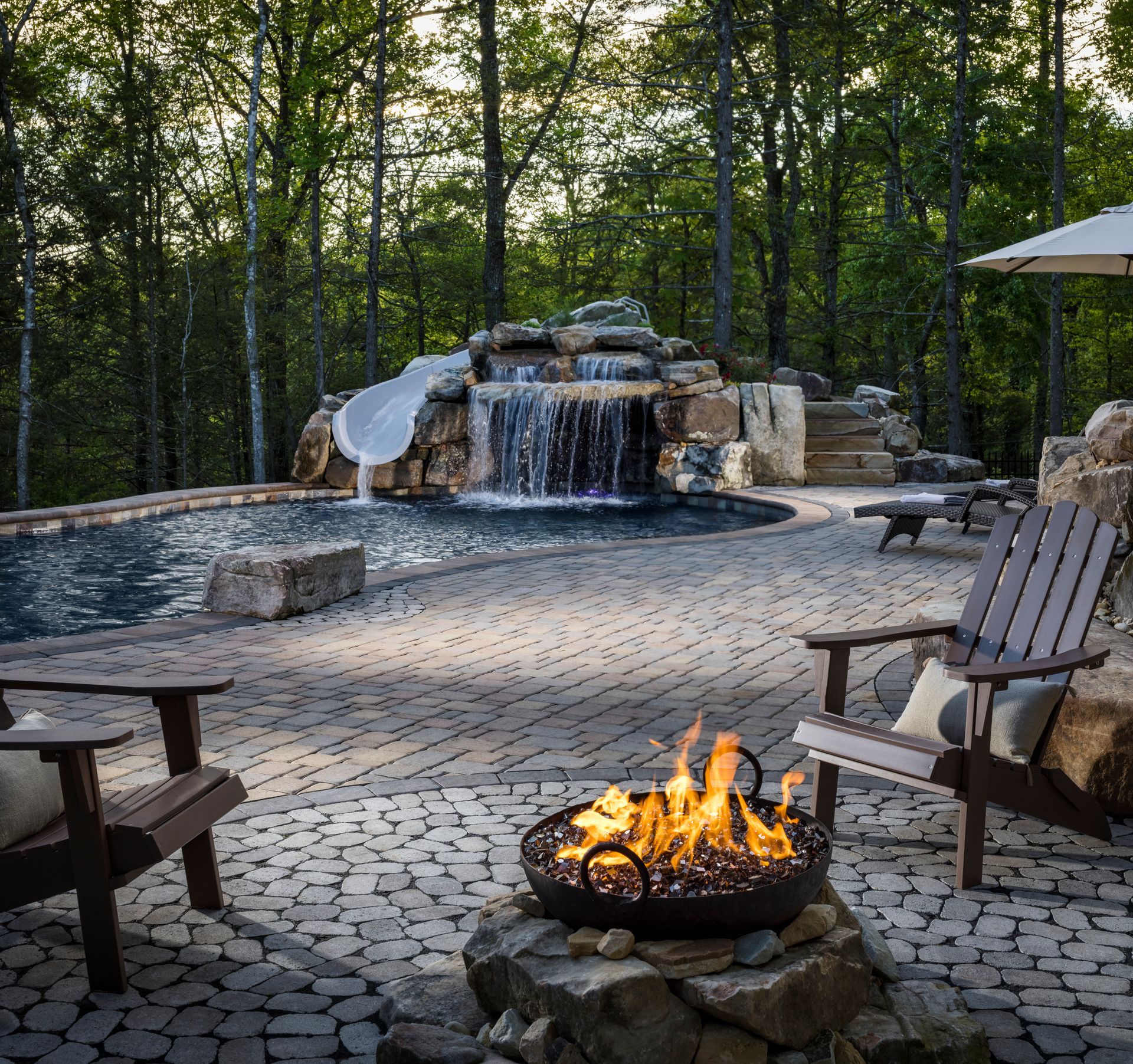 A fire pit with a waterfall in the background