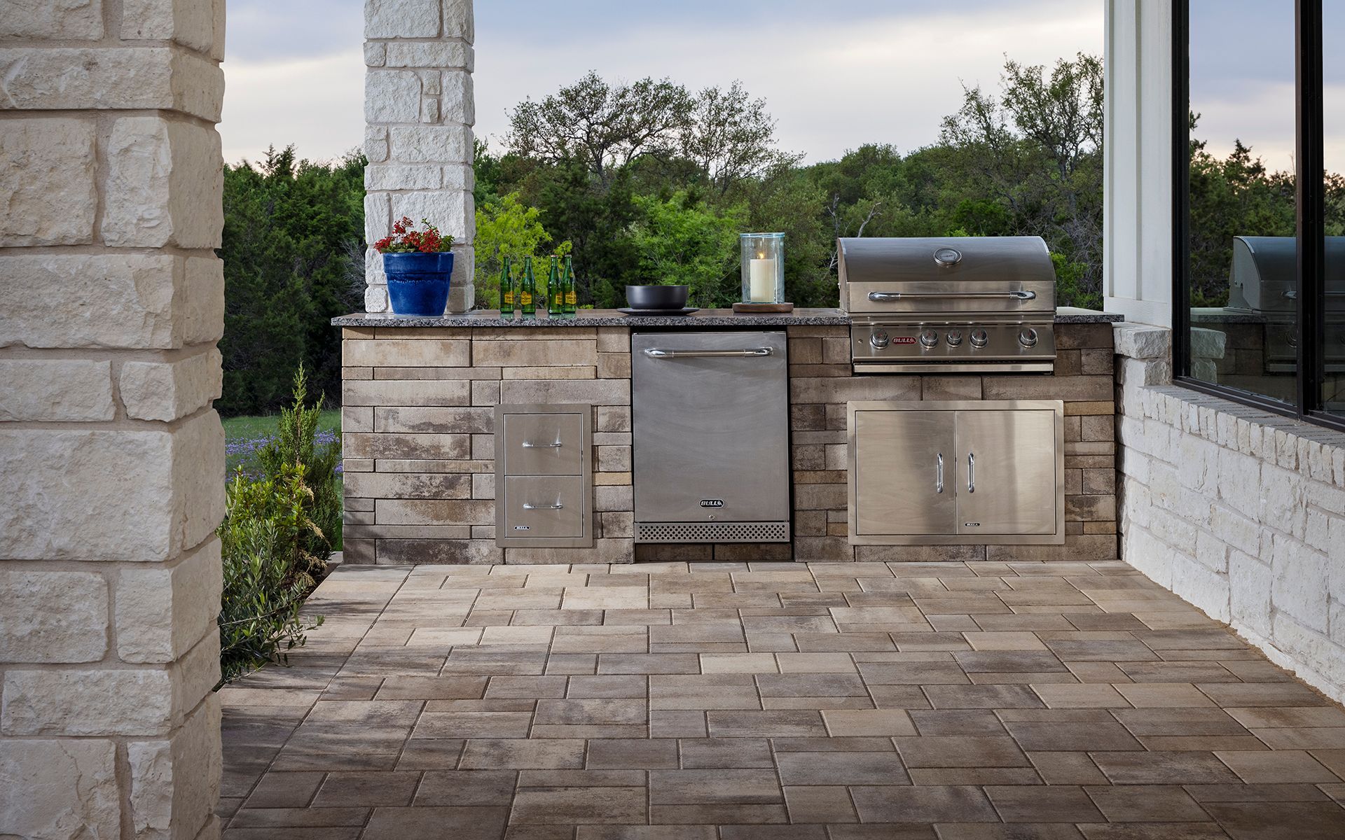 An outdoor kitchen with a grill and a dishwasher