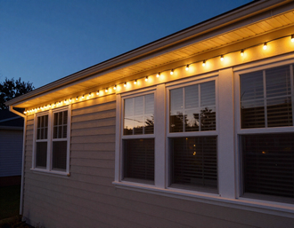 Warm white lights strung along a roofline and window trim