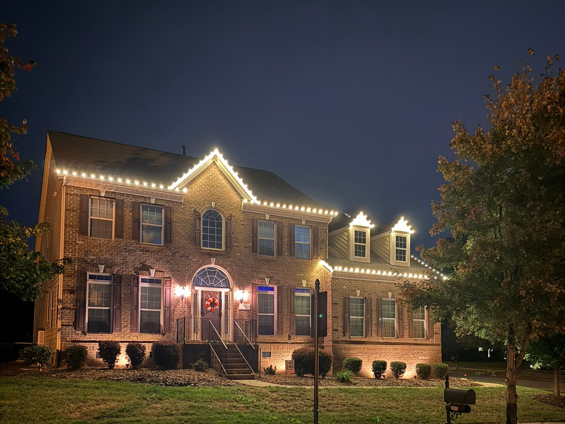 Christmas roofline lighting at night on a home in Huntersville