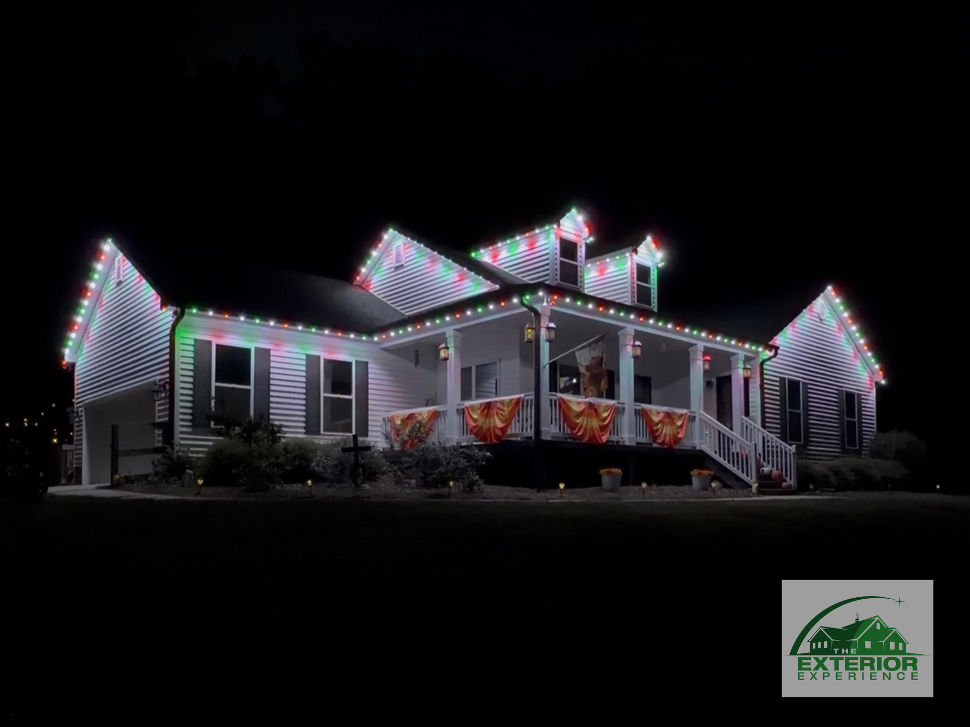 House outlined in colorful Christmas lights at night