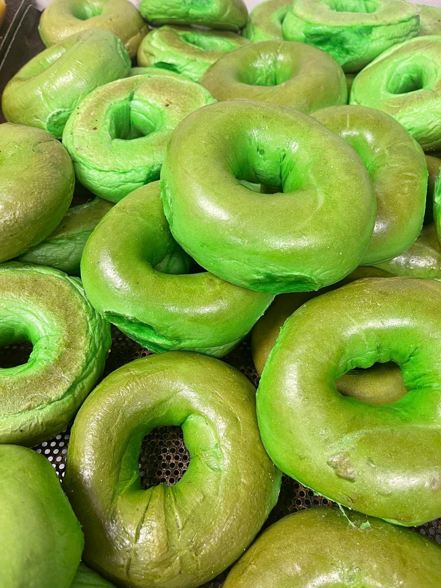 A Bunch Of Green Donuts Are Stacked On Top Of Each Other - Mahopac, NY - Our Town Bagels & Bakery