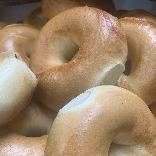 A Bagel With Butter On It Sits On A Yellow Surface - Mahopac, NY - Our Town Bagels & Bakery A Bagel With Butter On It Sits On A Yellow Surface - Mahopac, NY - Our Town Bagels & Bakery