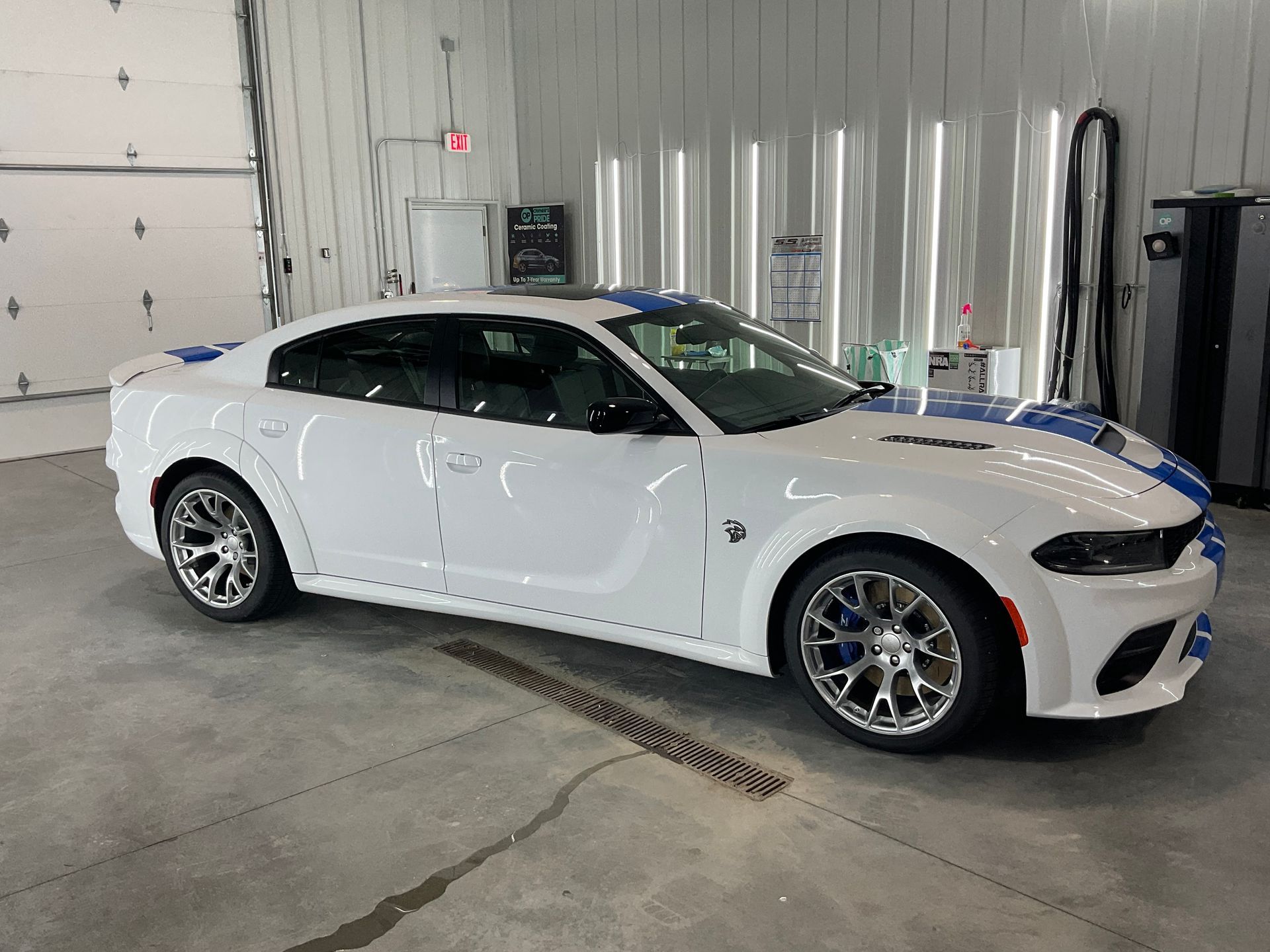 White sports coupe parked inside an industrial garage