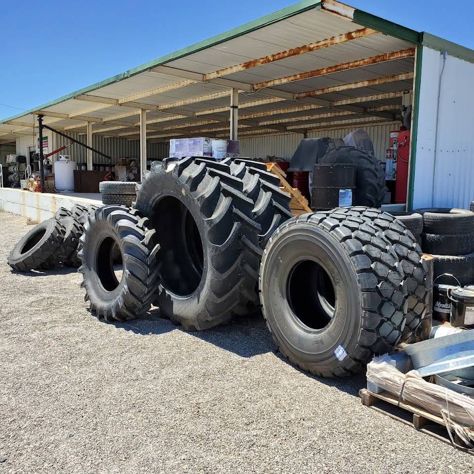 a bunch of tires are stacked in front of a building
