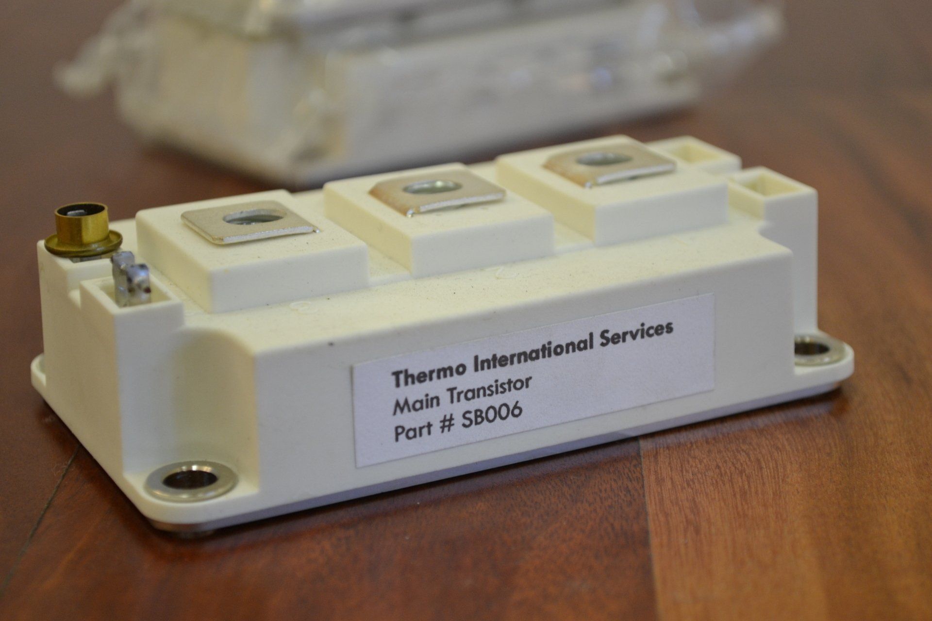 A thermo international services transistor is sitting on a wooden table.