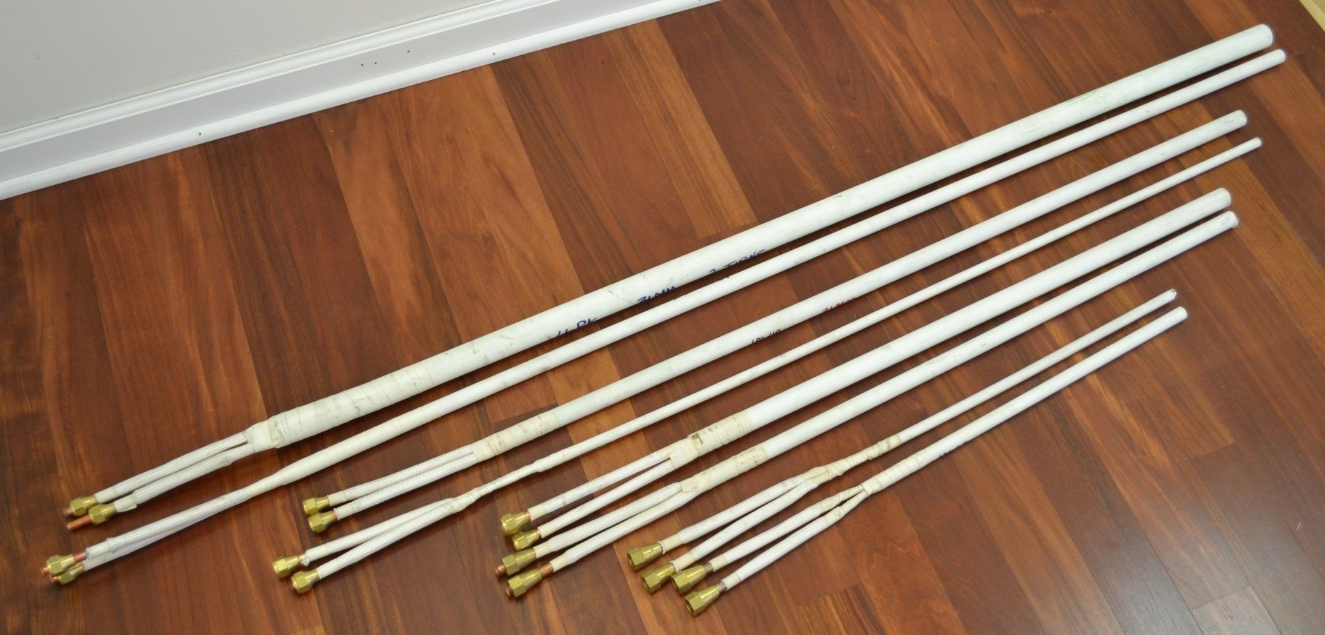 A bunch of white poles are sitting on a wooden floor.