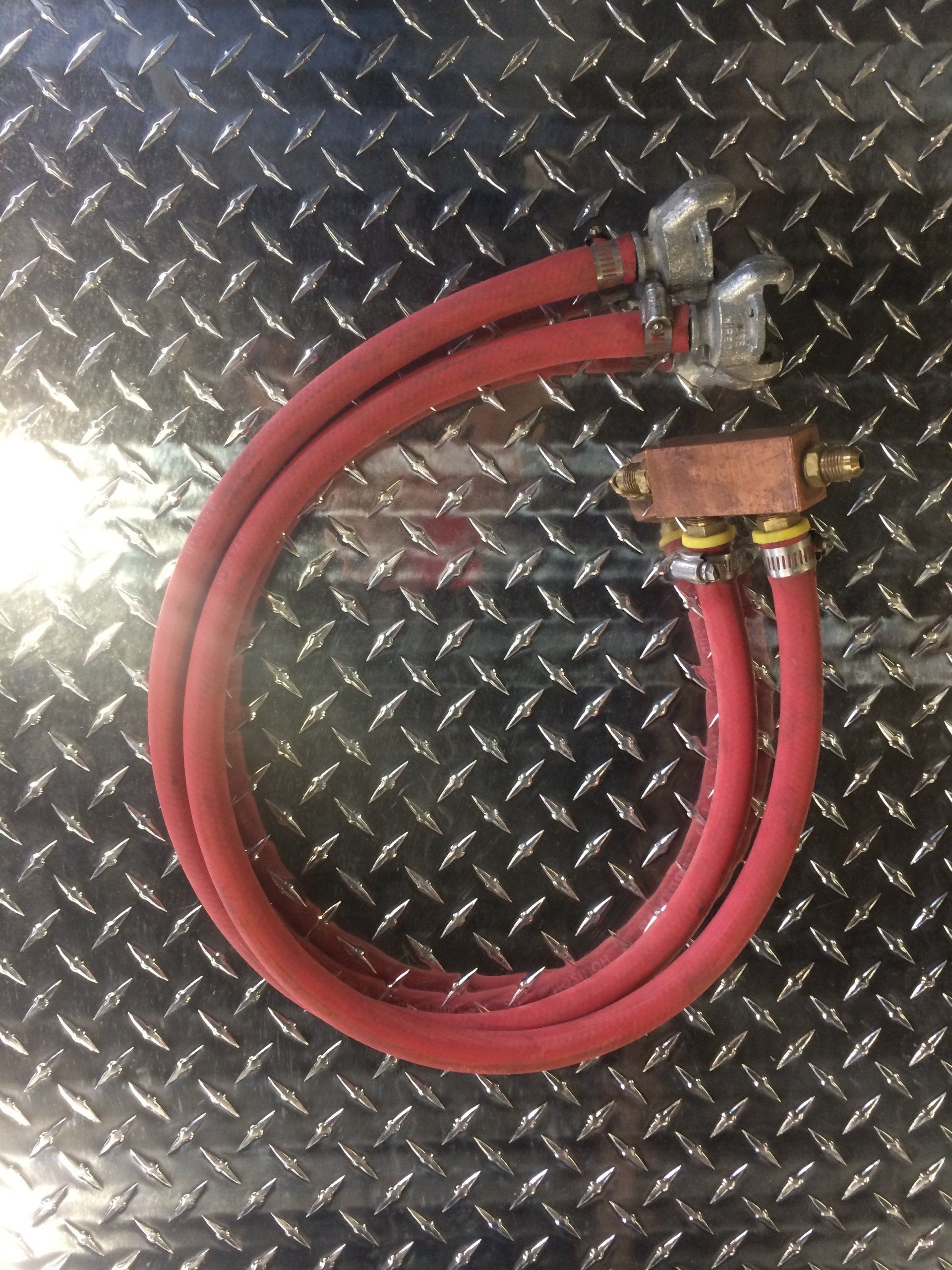 A pair of red hose connected to a metal surface